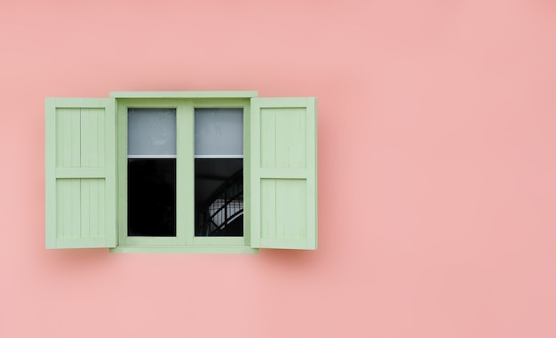 Photo vintage ouvert volets de menthe verte et fenêtres en bois isolés sur rose