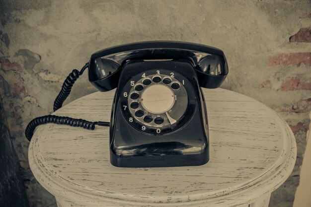 Vintage téléphone noir sur fond de vieux murs