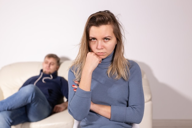 Violence domestique, abus et concept de famille - femme qui pleure et son mari en arrière-plan.