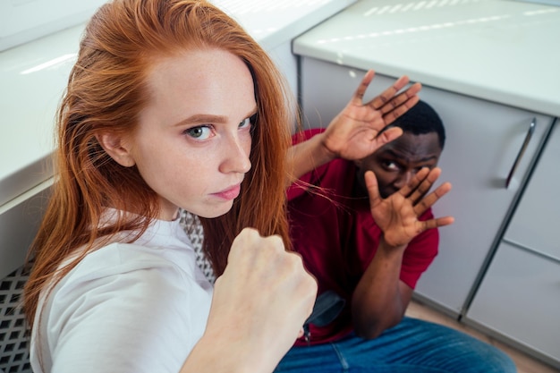 Violence domestique. fille en colère frappant un homme afro-américain à la cuisine.