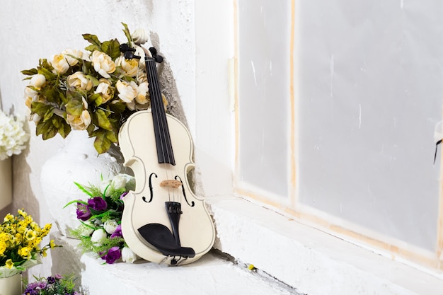 Violon blanc avec fleurs et salle blanche