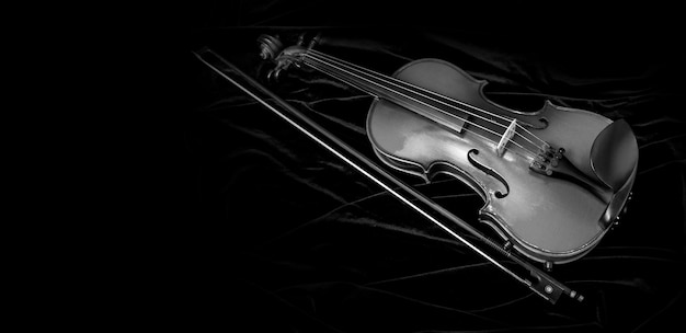 Violon brillant et archet isolé sur fond de velours noir