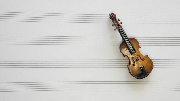 Photo un violon miniature se trouve au-dessus de la partition