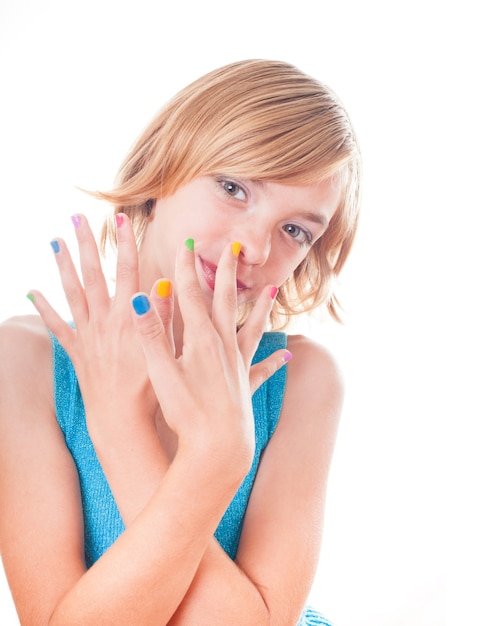 Le visage d'une adolescente blonde avec des ongles multicolores se bouchent