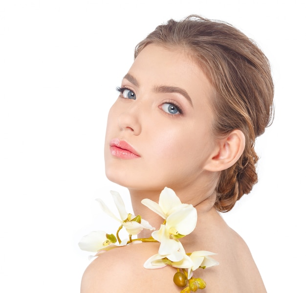 Visage beauté de la belle jeune femme avec une fleur