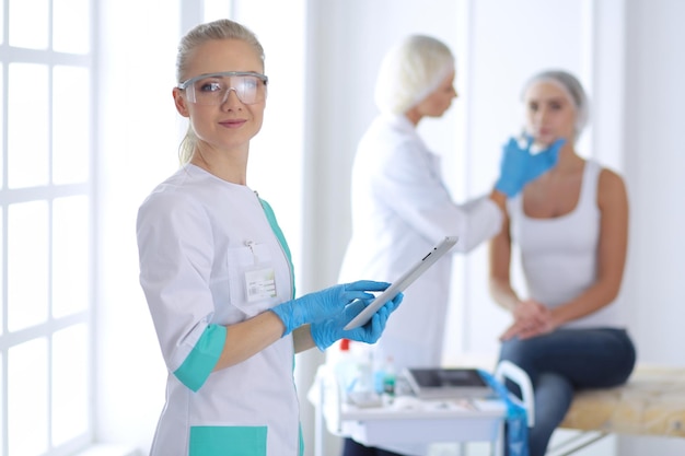 Visage de belle femme près d'un médecin avec une seringue