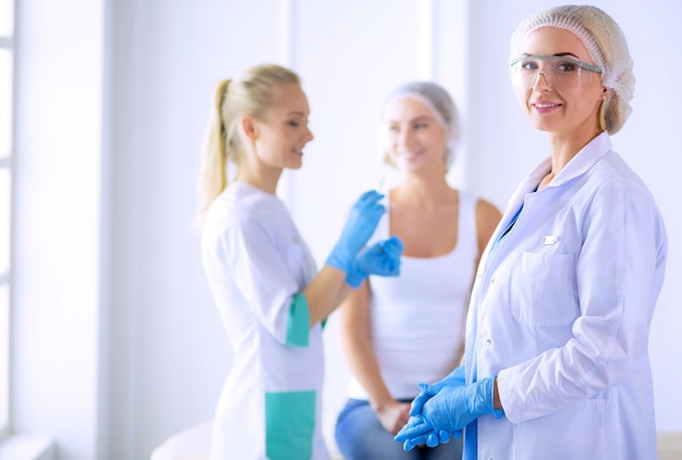 Visage de belle femme près d'un médecin avec une seringue