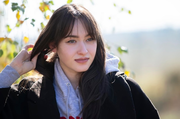 Le visage d'une belle jeune fille qui redresse ses cheveux et ne regarde pas la caméra