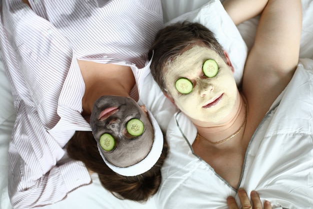 Visage bouchent masque cosmétique et tranche de concombre sur les yeux.