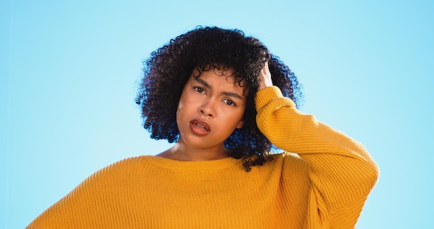 Photo visage confus et pensant par une femme noire en studio pensive et se demandant sur fond bleu portrait de doute et fille incertaine avec choix de décision ou emoji sur le placement de produit maquette ou isolé