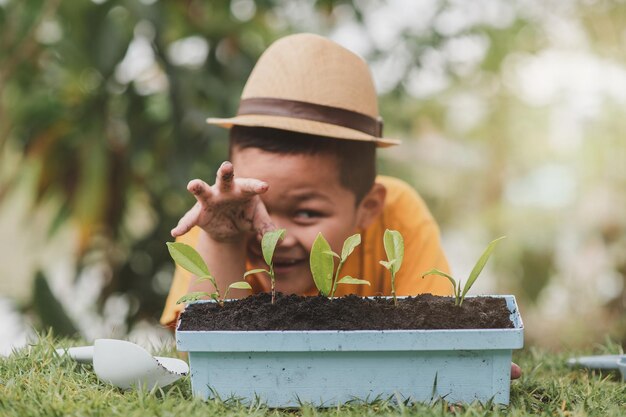 Photo le visage du petit jardinier regardait pousser les arbres