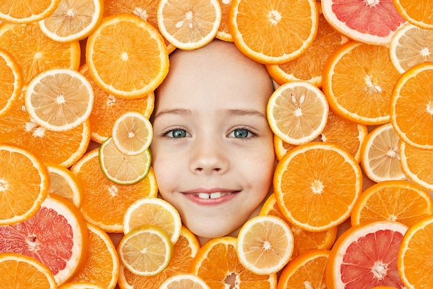 Le visage d'un enfant est entouré d'oranges