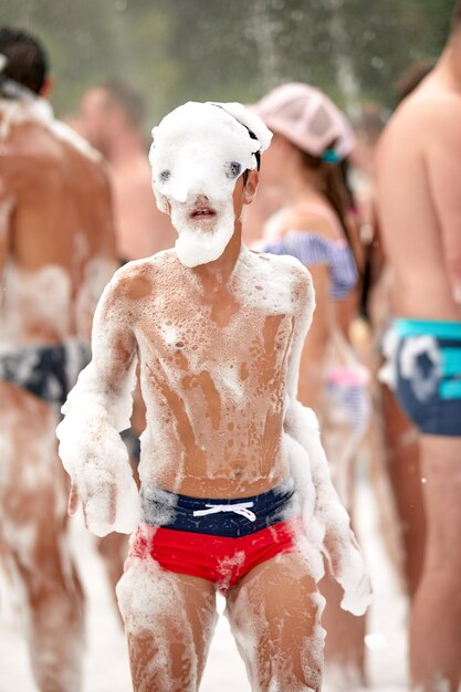 Visage d'un enfant en mousse enfant enthousiaste joyeux à une fête en mousse gros plan d'un enfants parmi la mousse