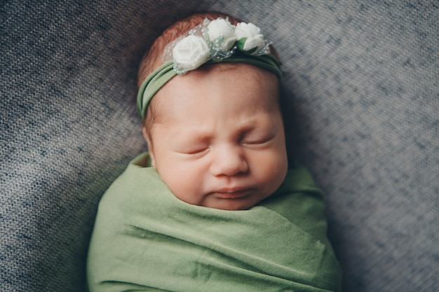 Le visage d&#39;un enfant avec un pansement avec des fleurs sur la tête