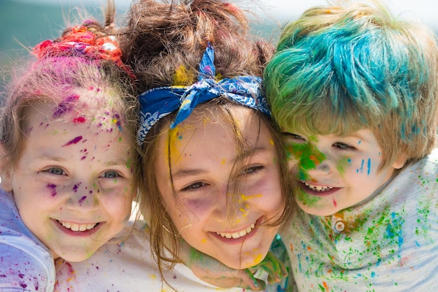 Visage d'enfants peints sur fond coloré holi closeup Festival des couleurs Les enfants dessinent des peintures