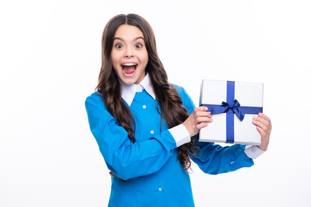Visage excité Enfant adolescent émotionnel tenir un cadeau pour l'anniversaire Drôle enfant fille tenant des boîtes-cadeaux célébrant la bonne année ou Noël Expression étonnée joyeuse et heureuse