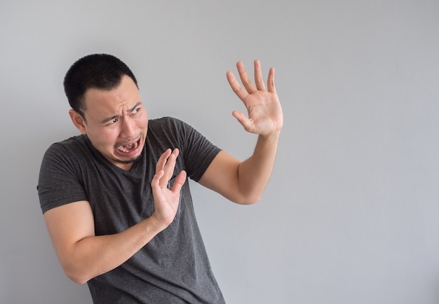 Visage d&#39;expression triste et effrayé de l&#39;homme asiatique en t-shirt noir.