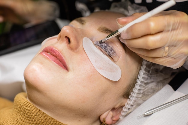 Visage féminin sous procédure de stratification des cils dans un salon de beauté