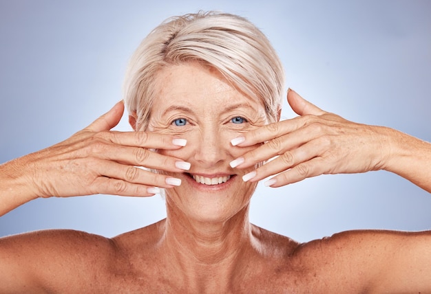 Visage de femme âgée et beauté manucure soins de la peau et sourire pour les soins de santé de bien-être du visage ou anti-âge sur un fond de studio gris