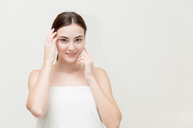 Visage de femme de beauté avec la main présente sa forme de visage isolée sur studio blanc