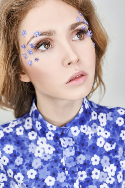 Visage de femme avec des fleurs bleues