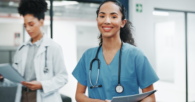 Visage fier d'une femme médecin dans un hôpital très fréquenté pour le leadership des services de santé et un état d'esprit de carrière heureux. Portrait confiant d'un jeune professionnel de la santé ou d'une infirmière dans une clinique ou un emploi dans le secteur des soins de santé.