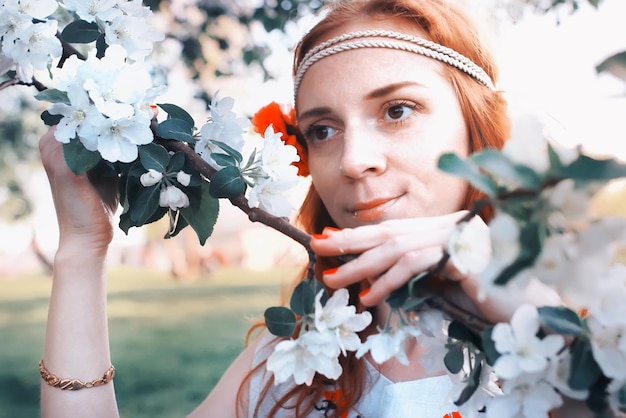 Visage de fille dans la branche de fleur de pomme