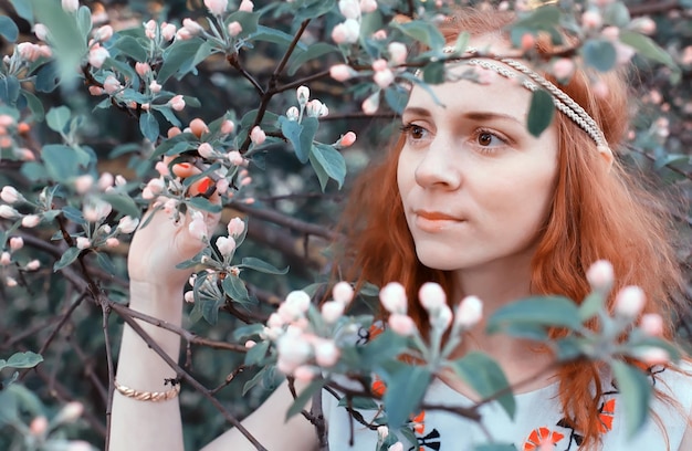 Visage de fille dans la branche de fleur de pomme