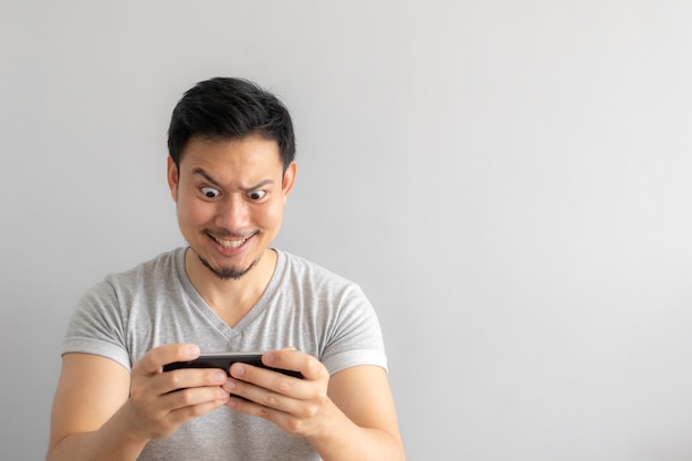 Visage fou et drôle de l&#39;homme accro au jeu mobile.