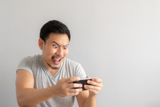 Visage fou et drôle d&#39;un homme accro au jeu mobile.