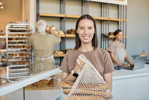 Visage généré par IA d'un jeune boulanger heureux faisant la présentation d'un nouvel assortiment