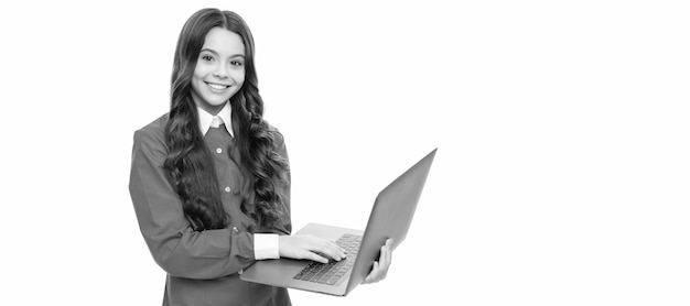 Visage heureux d'une adolescente aux longs cheveux bouclés travaillant sur ordinateur isolé sur le blog de l'école blanche Portrait d'écolière avec affiche horizontale pour ordinateur portable En-tête de bannière avec espace de copie