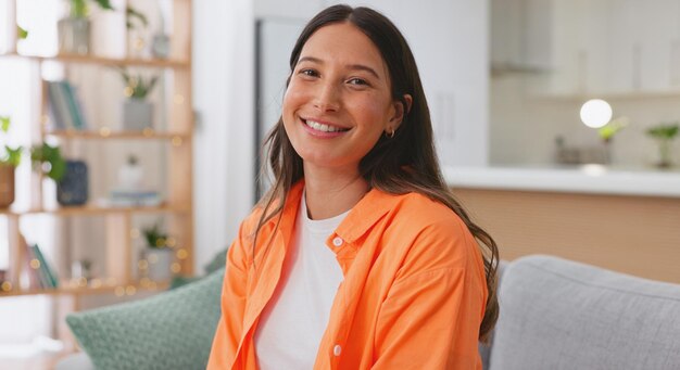 Photo visage heureux et femme sur le canapé se détendre et positif dans le salon insouciant et se reposer portrait femme et femme américaines sur le canapé sourire et soulagement du stress dans le salon fille avec bonheur ou gai