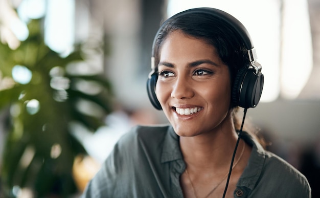 Visage heureux de jeune femme écoutant de la musique sur des écouteurs heureux et détendu à la maison Femme souriante tout en passant son temps libre à profiter d'un livre audio ou à apprendre une nouvelle langue le week-end