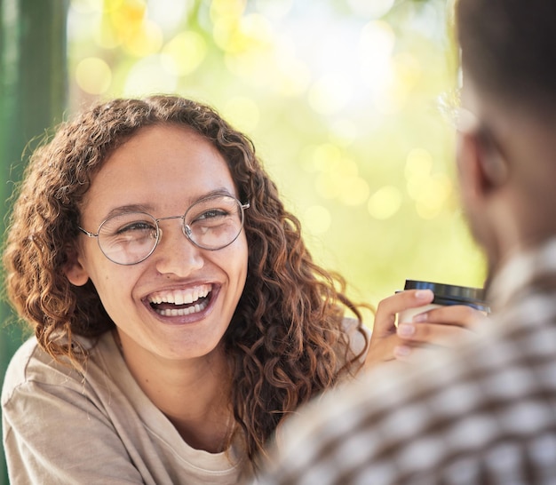 Visage heureux ou rendez-vous et une femme noire buvant du café dans le parc avec son petit ami pendant l'été Sourire d'amour et de rencontres avec une jeune femme souriant à son partenaire pour la romance ou l'affection