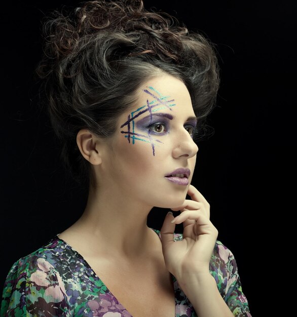 Visage de jeune femme avec un maquillage multicolore fashion lumineux