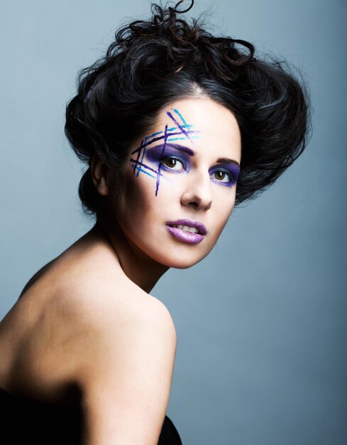 Visage de jeune femme avec un maquillage multicolore fashion lumineux