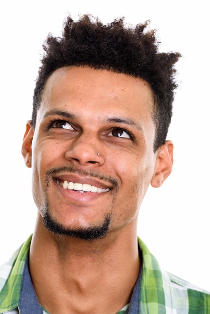 Visage de jeune homme africain heureux souriant tout en pensant isolé sur blanc