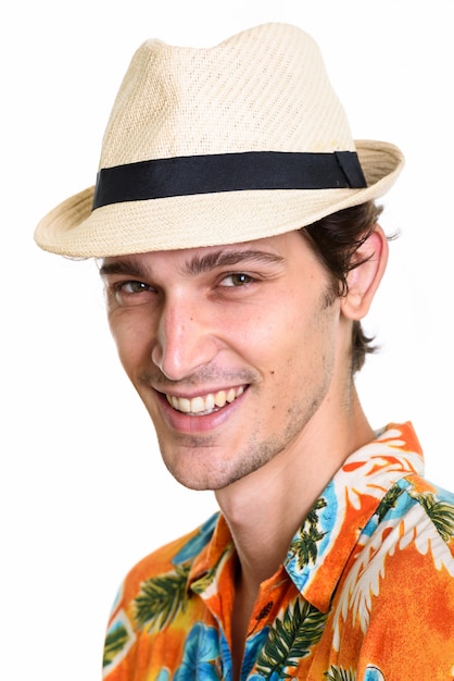 Visage de jeune homme beau heureux souriant tout en portant un chapeau