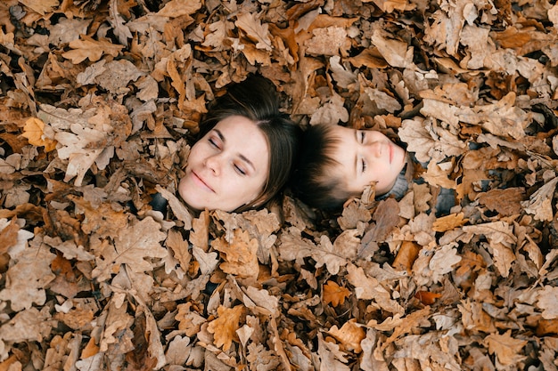 Le visage de la mère et du fils parmi les feuilles