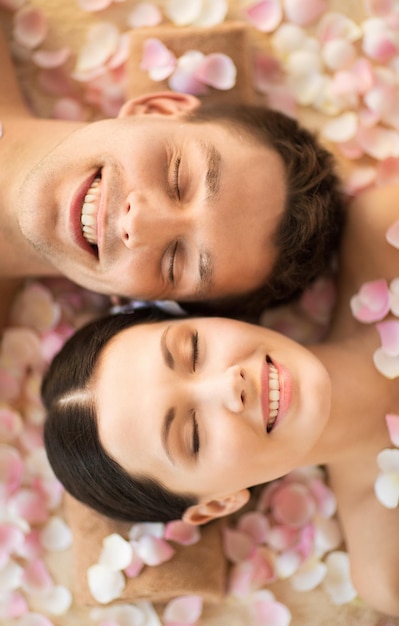 visages de couple dans un salon spa allongé sur les bureaux de massage