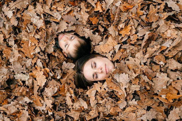 Les visages de la mère et du fils parmi les feuilles d'automne