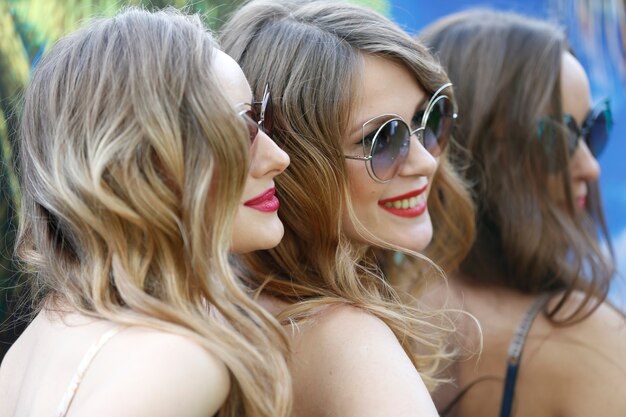 Les Visages De Trois Modèles. Femmes En Lunettes De Soleil