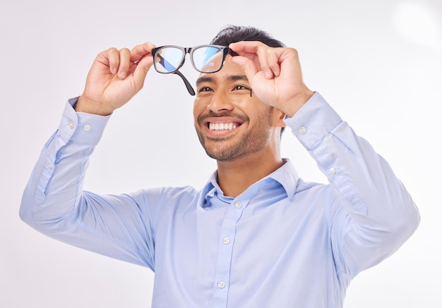 Vision de lunettes et homme heureux en studio pour lentille ou cadre de soins oculaires isolé sur fond blanc Sourire d'un visage de modèle masculin asiatique excité avec des lunettes d'optométrie dans les mains pour vérifier la vue ou la mise au point