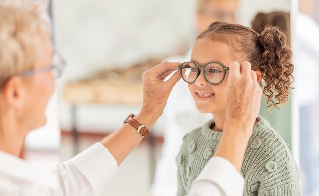 Photo vision lunettes de soins oculaires et enfant avec optométriste pour une consultation en ophtalmologie aide ou soutien à la vue service de soins de santé contrôle optique et consultation d'un jeune patient à l'examen de la vue