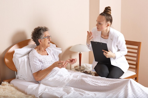 Visite d'une assistante sociale senior à une vieille femme