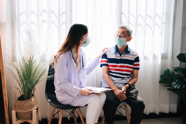 Visite d'un médecin asiatique et examen d'un homme âgé à la maison