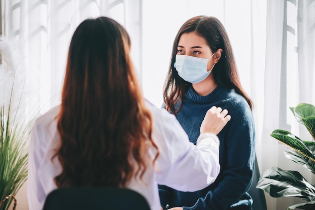 Visite d'un médecin asiatique et examen d'une jeune femme adulte à l'hôpital souffrant du syndrome du bureau et de la dépression