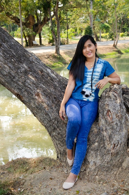 Visite de voyage d'une femme thaïlandaise en Asie et debout posant pour prendre une photo dans un parc de jardin public à Sing Buri en Thaïlande