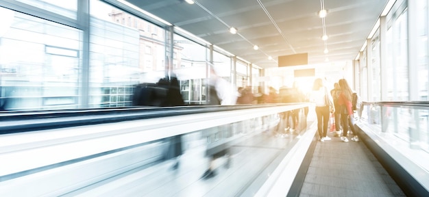 les visiteurs flous du salon se précipitent sur un escalator